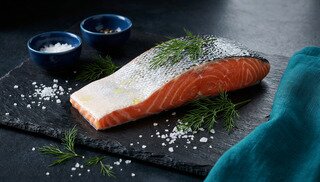 Filete de salmón fresco sobre pizarra oscura